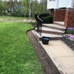Before shot of Manchester NH mulching service recently performed. Grass is evenly trimmed and area for laid mulch is cleanly defined along walkway.