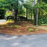 Check out the after shot of the landscaping project we recently tackled in Manchester NH. This image shows the end of the driveway with a cleaned garden bed including fresh mulch. The NH Lawn Care Services truck is in the distance at the end of the driveway.